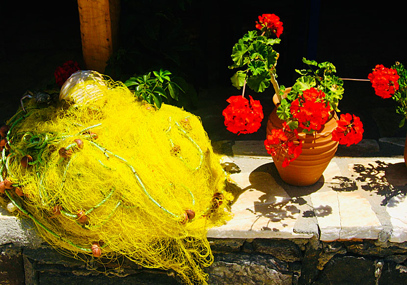 A beautiful composition of yellow fishing nets and red geraniums in Naxos.
