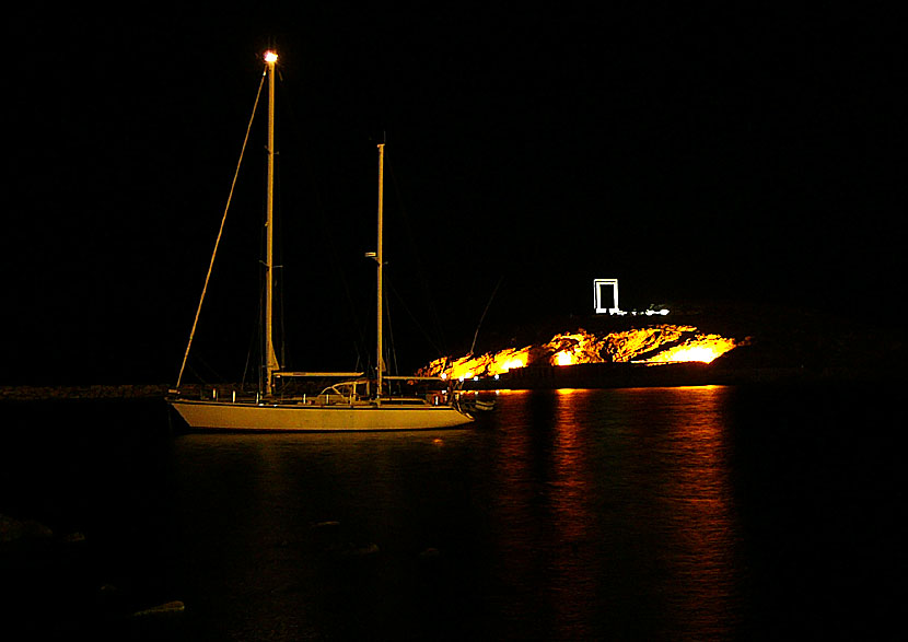 Palatia island and Portara in Naxos are illuminated in the evening.