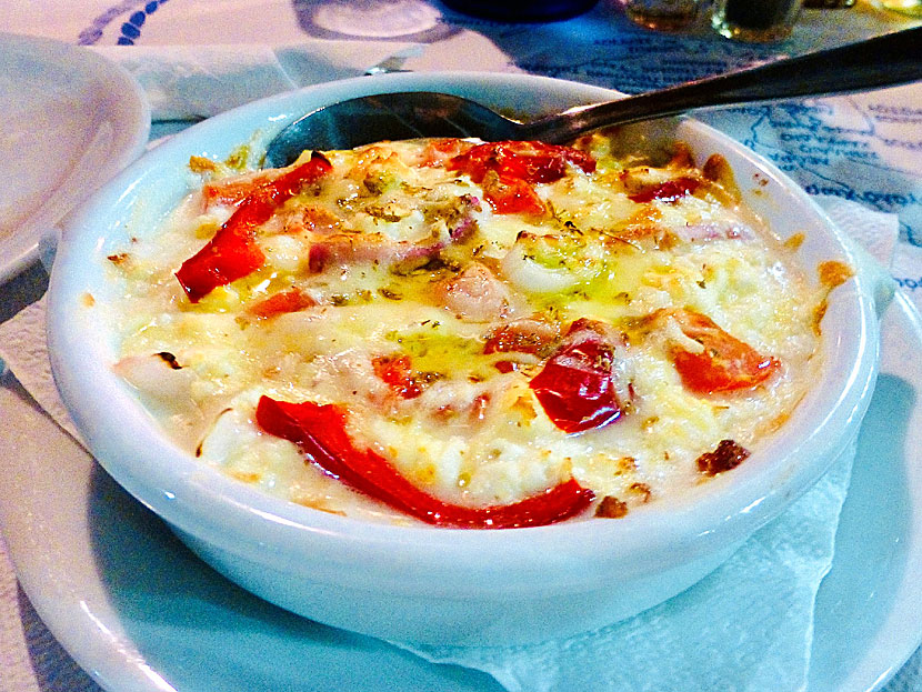 Starters and appetizers from Greece. Baked feta - Feta sto fournou - with pepper, tomato, onion, oregano, chili and olive oil.